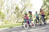 image of family  - Young Family Riding Bikes In Park - JPG 