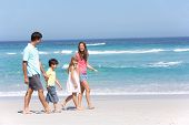 image of holidays  - Family Walking Along Sandy Beach - JPG 