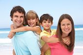 image of holidays  - Family Having Piggyback Fun On Beach Holiday - JPG 