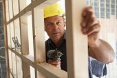 stock photo of buildings  - Construction Worker Building Timber Frame In New Home - JPG 
