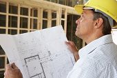 stock photo of home  - Architect With Plans In New Home - JPG 