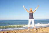 stock photo of fitness  - Senior Woman In Fitness Clothing Stretching On Beach - JPG 