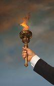 picture of leadership  - arm of a businessman holding a torch high - JPG 