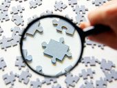 image of puzzle  - Hand with magnifying glass and puzzle isolated on white background - JPG 