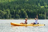 pic of rows  - Young couple waving and rowing kayak on river summer vacation - JPG 