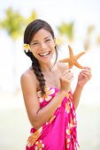 stock photo of multicultural  - Summer vacation woman smiling happy holding starfish on Hawaiian beach - JPG 