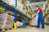 stock photo of food  - worker with fork pallet truck stacker in warehouse loading Group of food packages - JPG 