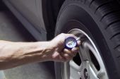 picture of pressure  - Mechanic checking tire pressure for increased gas milage - JPG 