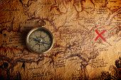 picture of map  - Old brass compass lying on a very old map showing the way to treasure - JPG 