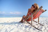 pic of beach  - Young lady relaxing in a chair on a beach at sunny day - JPG 