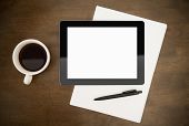 picture of portable  - Blank digital tablet with paper pen and cup of coffee on worktable - JPG 