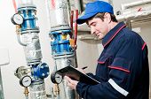 foto of pressure  - maintenance engineer checking technical data of heating system equipment in a boiler room - JPG 
