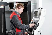 foto of industrial  - mechanical technician worker at cnc metal machining milling center in tool workshop - JPG 