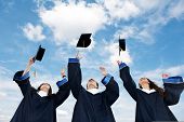 foto of hat  - three graduate students tossing up hats over blue sky - JPG 