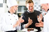 foto of restaurant  - Chef team in restaurant kitchen with dessert - JPG 