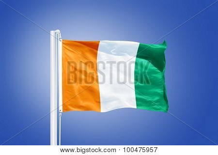 Flag of Cote d'Ivoire flying against a blue sky.