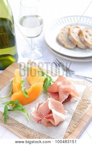 Prosciutto served with rockmelon, a common Italian antipasto with a glass of wine 