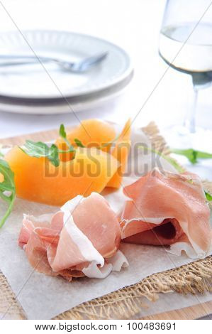 Parma ham served with rockmelon, a common Italian antipasto with a glass of wine 