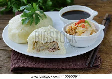 Korean steam meat pies (pigodi) served with soy sauce and kimchi