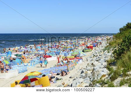 REWAL - AUGUST 13: Tourists enjoy the sunny weather and relaxing on the Baltic sea beach on 13 August 2015 in Rewal, Poland.
