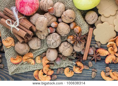 Apples, pears, walnuts, pine nuts, hazelnuts, cinnamon and star anise on the table