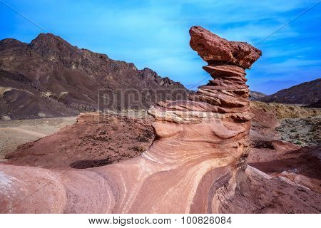 Outcrops of red sandstone unusual forms. Dry mountains of Eilat on a warm day in January