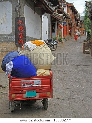motor tricycle with sacks on the street in Lijiang