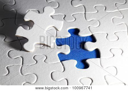 Plain white jigsaw puzzle, on Blue background, autism awarness