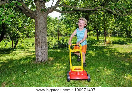Happy Small Boy Help With Gardening With His Lawn Mower