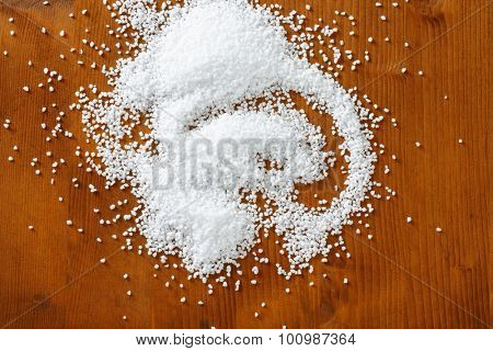 Coarse grained salt on wooden table