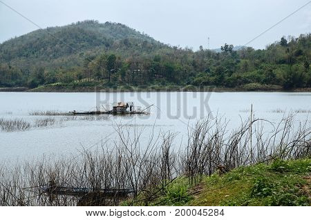 A fisherman works in his boat-house over Samorthong reservoir UthaiThani Thailand