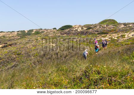 Group Trekking Over The Cliffs In Almograve