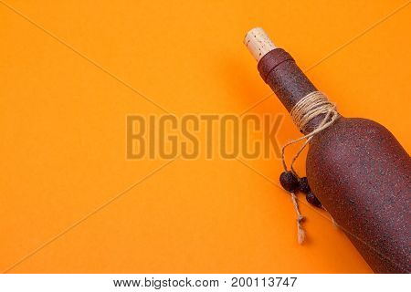brown bottle made of stone on an orange background