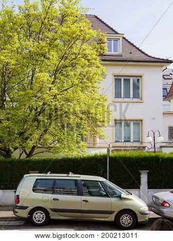 STRASBOURG FRANCE - APR 12 2017: Renault Scenic Espace mini van car parked on the French street under large tree and beautiful house behind