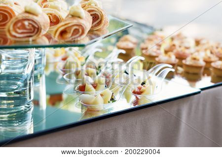 Appetizers, finger food, party food, sliders. Canape, tapas. Served table at summer terrace cafe. Catering service. Outdoor restaurant table with food