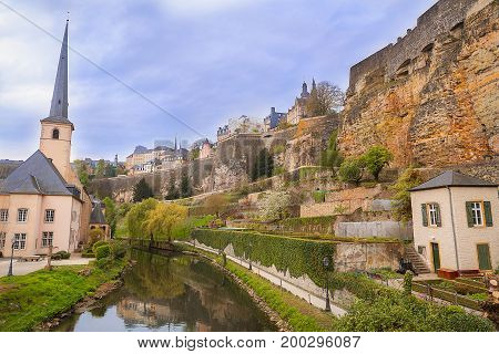 Ruins of the fortifications from the Former Castle of the Counts of Luxembourg reflected on the water of the Petrusse river.