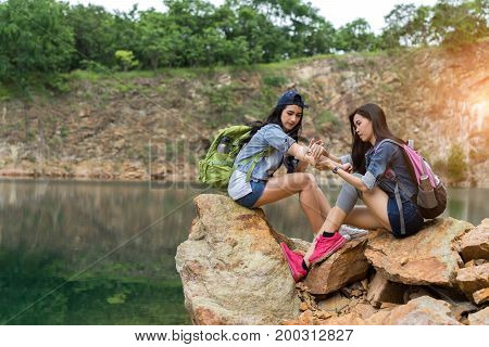 Young girl asian with backpack help friend hurt arm first aid elementary on the mountain travel trip adventure