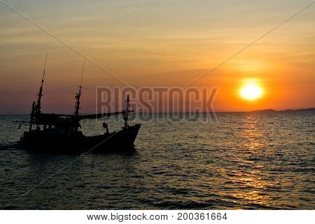 Old fishing boat In the rays of the setting sun