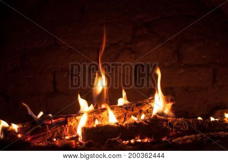 Small fire in the oven against a brick wall background