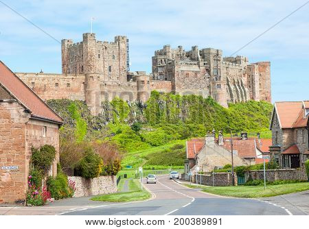 BAMBURGH, UNITED KINGDOM - JUNE 12, 2012: A view of the picturesque village of Bamburgh, in Northumberland in England, with Bamburgh Castle in the background.