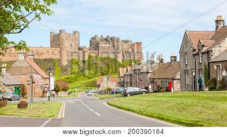 BAMBURGH, UNITED KINGDOM - JUNE 12, 2012: A view of the picturesque village of Bamburgh, in Northumberland in England, with Bamburgh Castle in the background.