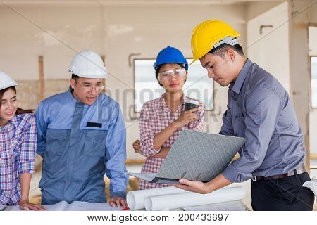 Harmonious Engineer And Technician Team Dicussing In Building Construction Site. Teamwork Collaborat