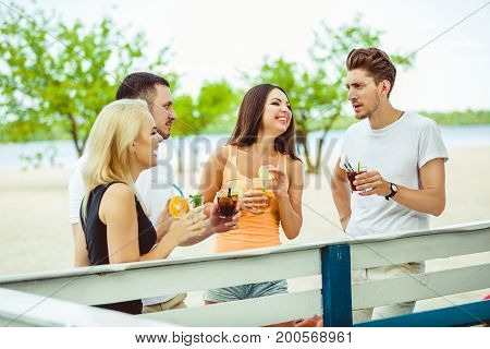 Friends having fun at the bar outdoors, drinking cocktails. Summer bar