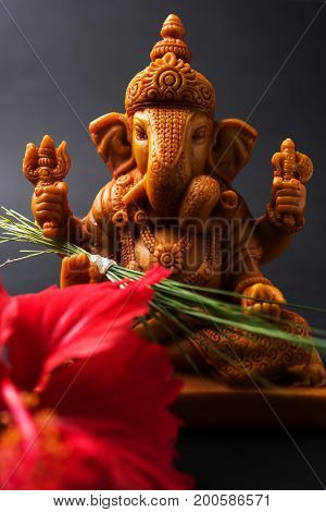 Happy Ganesh Chaturthi Greeting Card showing photograph of lord ganesha idol, pooja or puja thali, bundi laddu/modak, durva and hibiscus or jasvand flower