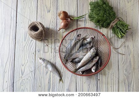 Fresh fish boops and vegetables on wooden table close-up.