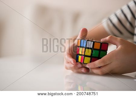 Moscow Russia August 16 2017: Rubik's cube in child's hands closeup. Boy holding Rubik's cube and playing with it.