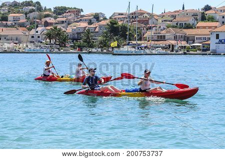 TROGIR, CROATIA - JULY 11, 2017: Tourists swim by boat along the bay in the town of Trogir, Croatia.