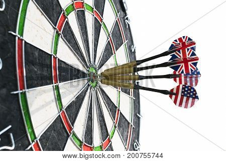 Metal darts have hit the red bullseye on a dart board. Darts Game. Darts arrow in the target center darts in bull's eye close up. isolated on white background.Success hitting