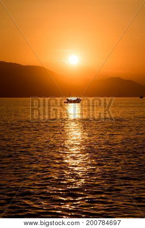 Fishing boat in the rays of the rising sun