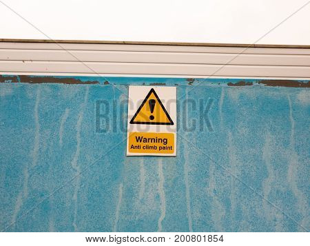 A Sign On Blue Wall Saying Warning Anti Climb Paint